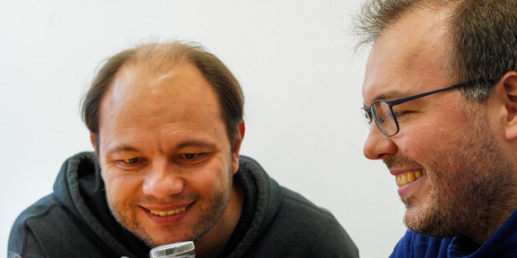 Marc Aßmann und Jörg Debus beobachten ein cooles Experiment.