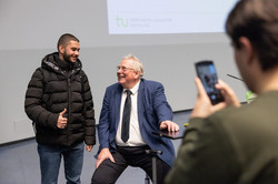 Person aus dem Publikum macht ein Foto mit Reinhard Genzel