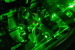 Detailaufnahme Laserlabor von Prof. Bayer - grüner Laser in dunklem Raum