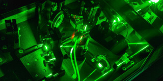 Detailaufnahme Laser im Labor_05 Eine Detailaufnahme eines Lasers im Labor in dunkel grünen Farben.