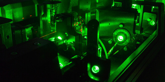 Detailaufnahme Laser im Labor_03 Eine Detailaufnahme eines Lasers im Labor in dunkel grünen Farben.